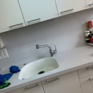 כיור מטבח עם ברז ומטליות ניקוי