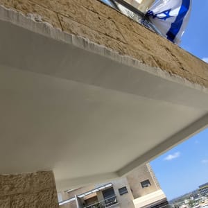 מרפסת בניין עם קיר אבן ודגל ישראל
