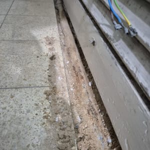 חול ואבנים ליד צינור חשוף ברצפה