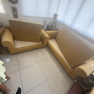 שני ספות צהובות בחדר עם רצפת קרמיקה