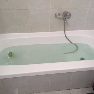 אמבטיה עם מים, ברז ומקלחת יד