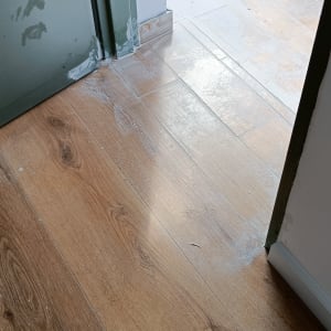 רצפת פרקט עץ עם כתמי צבע לבנים