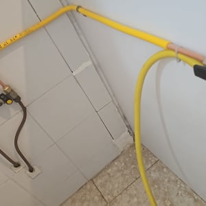 צינור גז צהוב מחובר לקיר לבן
