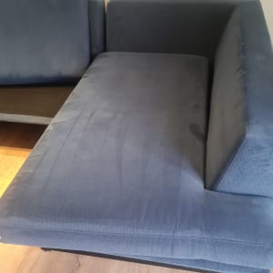 ספה כחולה על רצפת עץ בחדר מואר