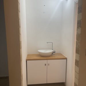 כיור על ארון עץ עם קיר לבן צבוע