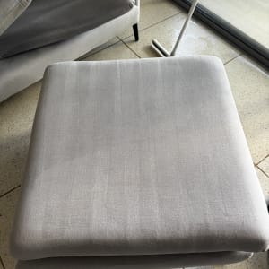 כרית ספה אפורה על רצפה ליד חלון