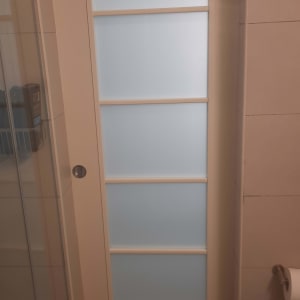 דלת פנים הזזה עם זכוכית חלבית בחדר רחצה
