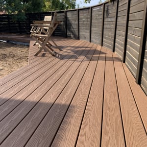 דק עץ עם כיסאות עץ וגדר עץ מסביב