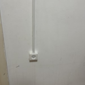 שקע חשמל על קיר לבן עם כבל חשמל