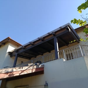 מרפסת עם פרגולה מעץ על בית