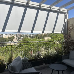 מרפסת עם פרגולה אלומיניום ונוף עירוני