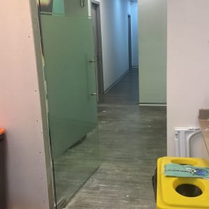 דלת זכוכית שקופה עם ידית מתכת במסדרון