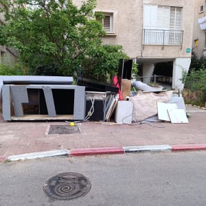 ערימת רהיטים ופסולת ברחוב ליד בניין מגורים