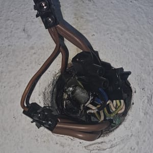 חוטי חשמל חומים מחוברים לקופסת חיבורים בקיר