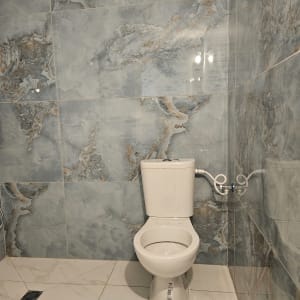 שירותים חדשים עם אריחים אפורים על הקיר