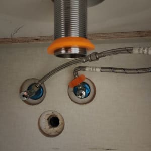 צינור מתכת עם חיבורים מתחת לכיור