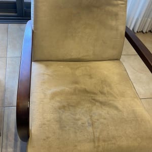 כורסה מרופדת בבד בהיר עם ידיות עץ כהות