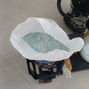 שקית עם שברי זכוכית ושואב אבק על הרצפה