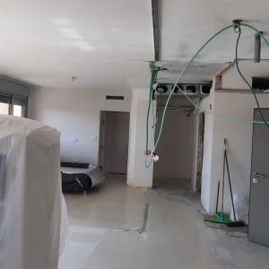 חוטי חשמל תלויים, דלת פתוחה, רצפה חשופה, ציוד מכוסה בניילון