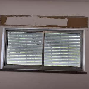 תריסים אופקיים סגורים על חלון זכוכית