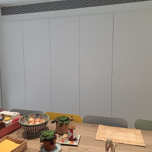 שולחן עם סלסלות, צנצנות, קערה וצמחים קטנים.