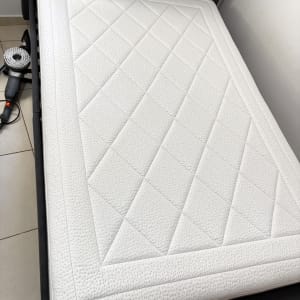 מזרן לבן עם מכונת ניקוי בצד