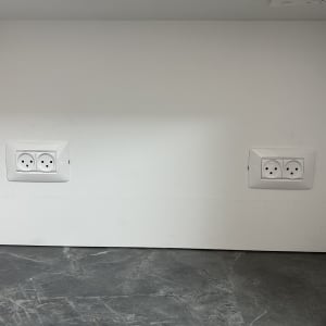 שני שקעים חשמליים מותקנים על קיר לבן