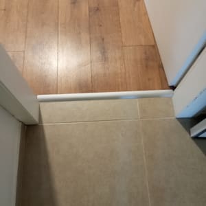 חיבור פרקט עץ לרצפת קרמיקה עם סף לבן