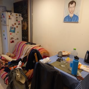 שולחן עם מפה משובצת, בקבוק מים, מספריים, תיק על ספה