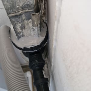 צינור פלסטיק מחובר לקיר עם אטם שחור