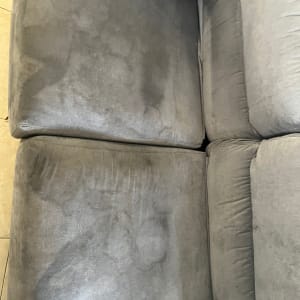 ספה אפורה עם כתמים כהים על המושב