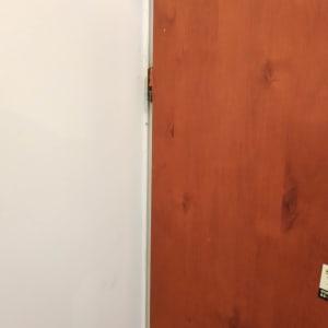 דלת עץ עם ציר מתכת בצד שמאל