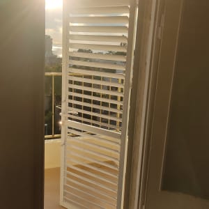 דלת אלומיניום עם תריסים פתוחים לאור השמש