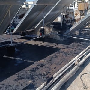 גג עם לוחות סולאריים ואיטום בזפת