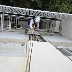 עובד בגובה עם קסדה וציוד בטיחות על גג בניין