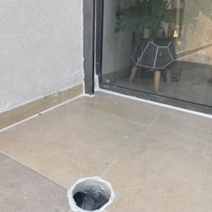 רצפה עם חור אטום ליד חלון וצמח