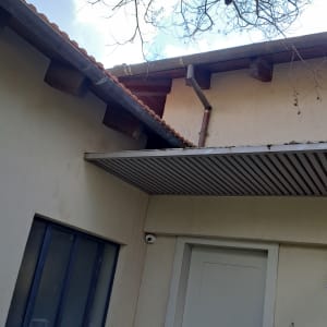 גג רעפים עם מרזב מתכת ועץ חשוף