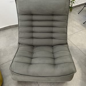 כיסא מרופד בצבע אפור על רצפת אריחים