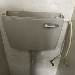 מיכל הדחה אפור עם צינור חיבור
