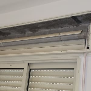 ארגז תריס גלילה ידני פתוח במהלך תיקון מעל חלון