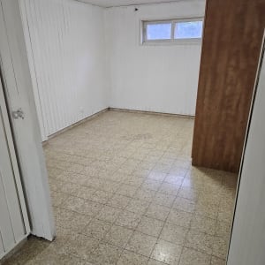 חדר ריק עם רצפה נקייה וקירות לבנים