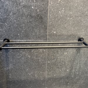 מתקן מגבות מתכת על קיר אפור