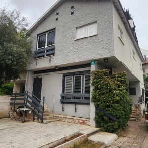 גג משופע עם רעפים אפורים וציפור יושבת עליו