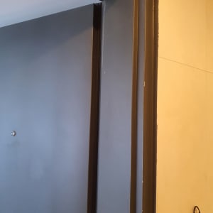 דלת צבועה בצבע כהה עם מסגרת מתכת