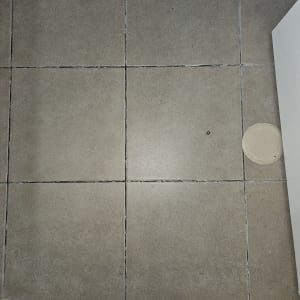 רצפת אריחים עם סימני רטיבות ונקודות שחורות