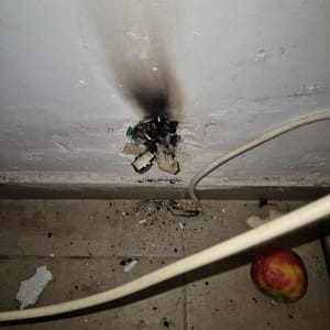 חוטים שרופים בקיר עם סימני פיח