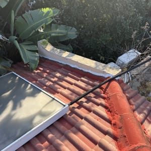 גג רעפים עם לוח סולארי וצמחייה מסביב