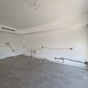 חוטי חשמל חשופים בקיר לבן בחדר ריק