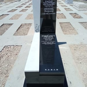 מצבה שחורה ולבנה עם כיתוב בעברית ובגאורגית