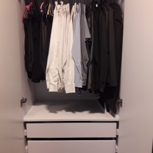 ארון בגדים עם חולצות תלויות ומגירות סגורות